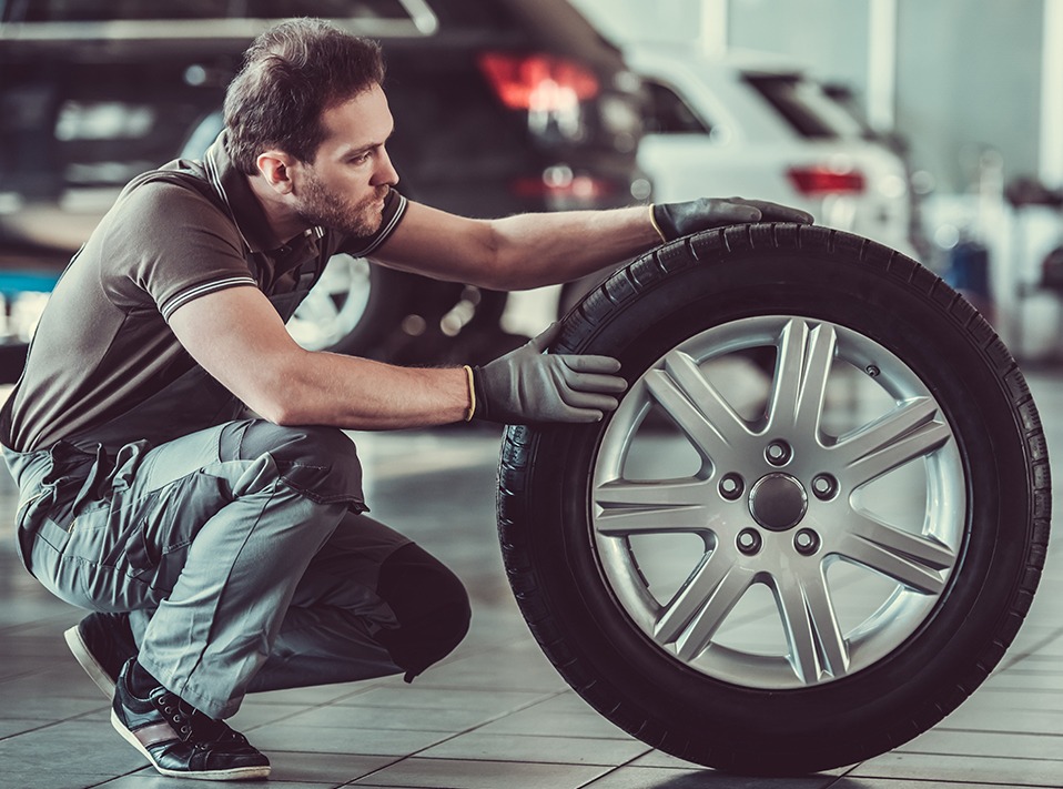 Mechanic holding a tyre - Car Repairs Mitcham