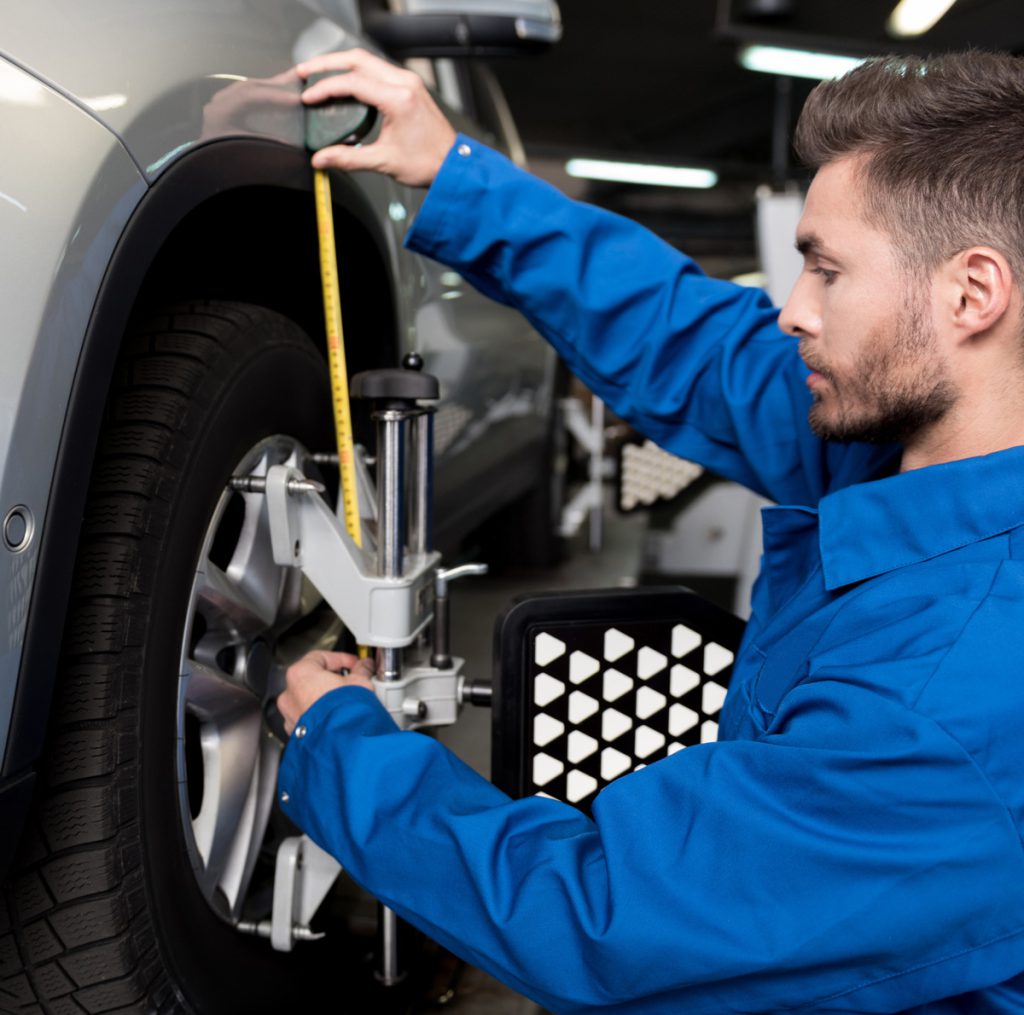 Mechanic checking a vehicles wheels - Wheel Alignment Mitcham